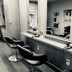 Zwart-wit foto's van kaptafel met stoel, spiegel en haardroger